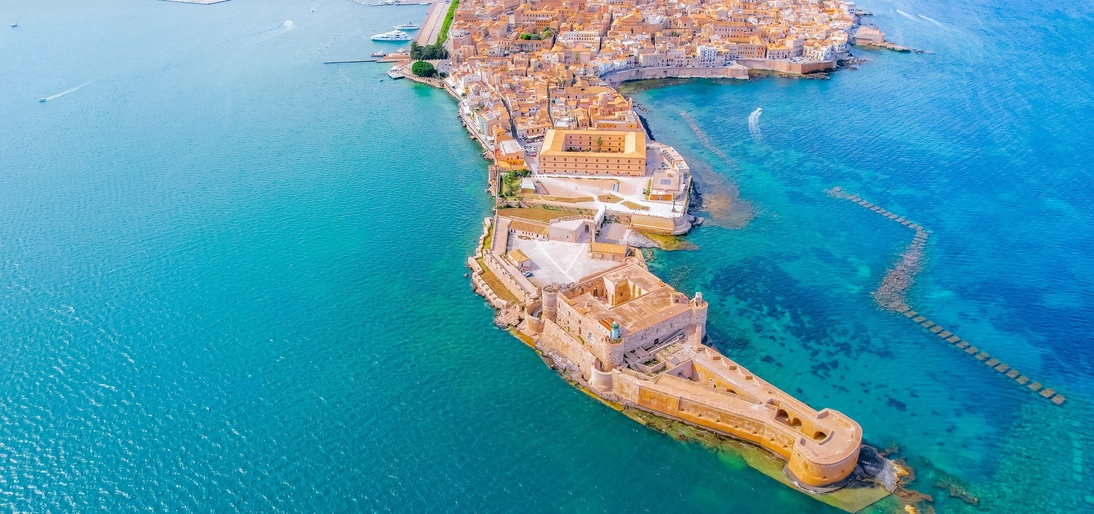 Aerial of Ortigia island, old town with turquoise sea of Syracuse. Small island on Sicily, Italy.
