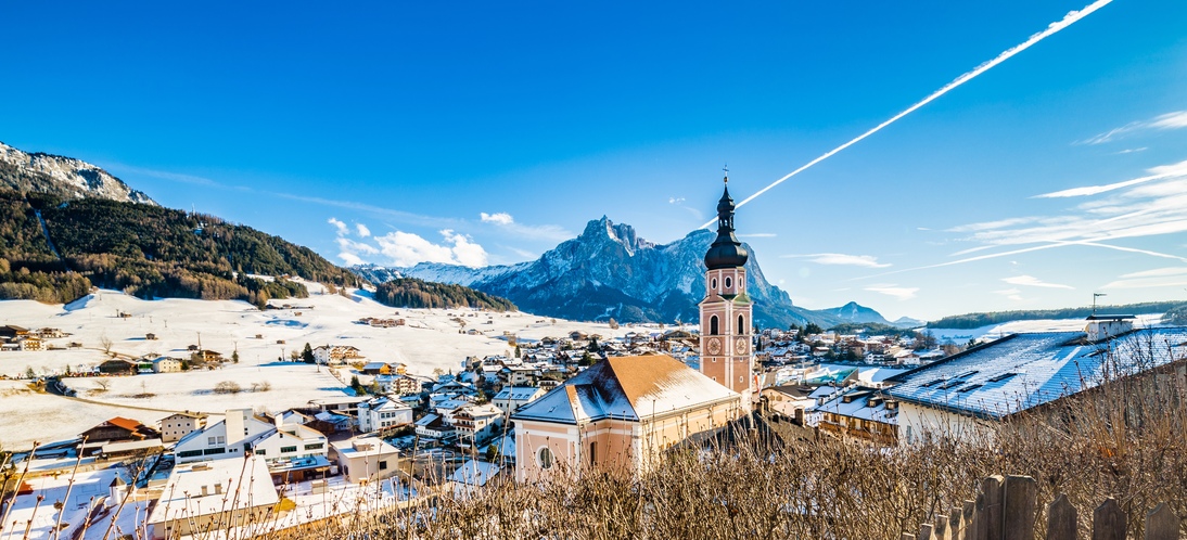 winter Alpine landscape in Italy, mountain village and snowy peaks